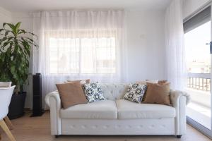 a white couch in a living room with a window at ApartRincón Candelaria in Rincón de la Victoria