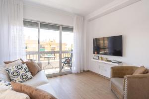 a living room with a couch and a tv and a balcony at ApartRincón Candelaria in Rincón de la Victoria +44 photos