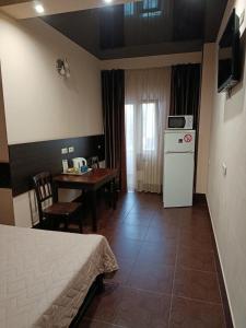 a room with a bed and a kitchen with a table at Genuez in Odesa