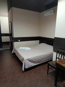 a small bedroom with a bed and a table at Genuez in Odesa