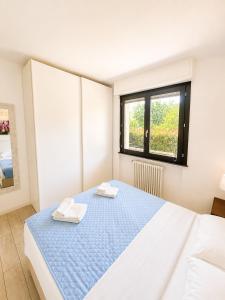 a bedroom with a bed with two towels on it at Lotus in Lenno +11 photos