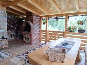 a living room with a brick fireplace and a table at Cabana La Bălănuț din Bucovina in Colacu