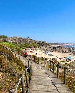 a man walking down a wooden path to a beach at TurisMar Vila do Conde in Macieiro da Maia