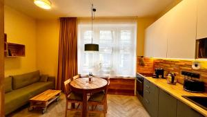 a kitchen with a table and a couch and a window at City Vibe Studio in Poznań