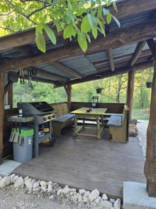 a patio with a picnic table and a grill at Apartment Hosner in Lepena
