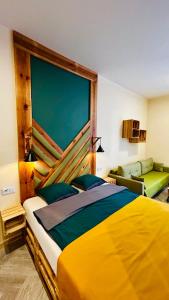 a bedroom with a large yellow bed and a couch at City Vibe Studio in Poznań
