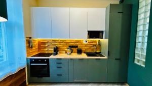 a kitchen with white cabinets and a sink and a stove at City Vibe Studio in Poznań +10 photos