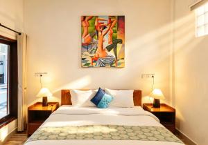 a bedroom with a bed and a painting on the wall at Brady's B&B Close To Sanur Beach in Sanur +44 photos