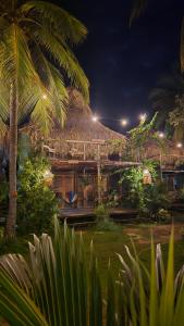 a resort building with a thatched roof at night at El cielo hotel isla fuerte in Puerto Limón