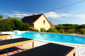 a swimming pool in front of a house at Chambres d'hôtes l'allegra in Saint-Euphrône
