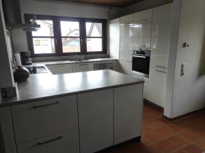 a kitchen with white cabinets and a counter top at Schöner Wohnen in Rheinau