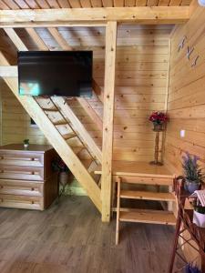 a room in a log cabin with a flat screen tv at Apartmani Kajkut in Banja Luka