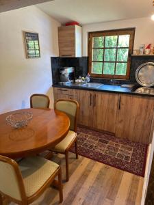 a kitchen with a wooden table and a table and chairs at Paradise on the Vrbas River in Jajce