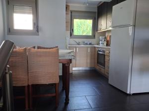 a kitchen with a table and a white refrigerator at Villa Alexander in Xanthi