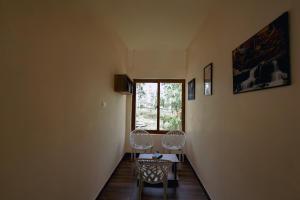 a hallway with two chairs and a table and a window at Kerala cottage in Varkala