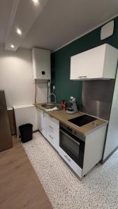 a small kitchen with a sink and a stove at joli petit studio breval in Bréval