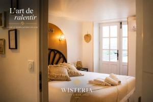 a bedroom with a bed with towels on it at Wistéria #Piscine #Terrasse privée #Route des vins in Azé