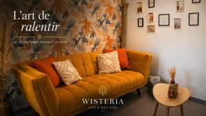 an orange couch in a living room with a wall at Wistéria #Piscine #Terrasse privée #Route des vins in Azé