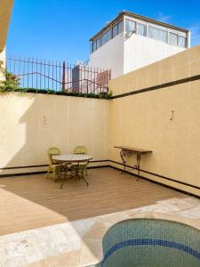 a patio with a table and a bench on a building at Loft a cinq minute de la plage in Temara