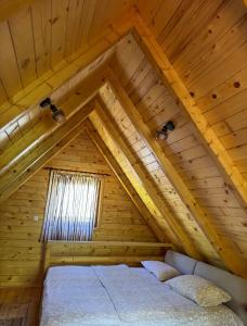 a room with a bed in a wooden attic at Apartmani Kajkut in Banja Luka