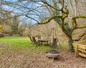 a garden with a table and chairs and a swing at La Grotta in Hinkel
