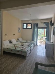 a bedroom with two beds and a window at Nikis studios in Skala Sotiros