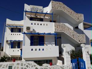 a white building with blue doors and windows at Sunshine in Maltezana