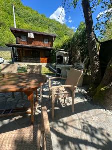 a picnic table and chairs in front of a house at Paradise on the Vrbas River in Jajce