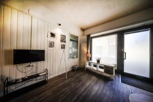 a living room with a television and a large window at Civico46 in Domodossola