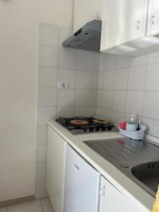 a white kitchen with a stove and a sink at La mia casetta in Taormina
