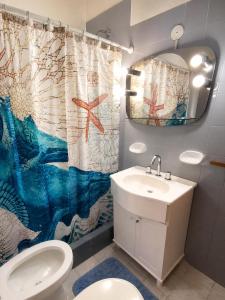 a bathroom with a sink and a toilet and a shower curtain at Departamento Mara in Puerto Madryn
