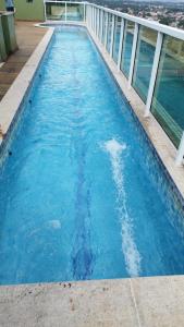 a swimming pool on top of a building with blue water at Apartamento Flat Itaboraí - Edifício Hélix in Itaboraí