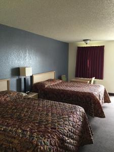 a hotel room with two beds and a window at Country Inn Motel in Waukomis