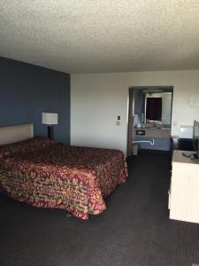 una camera d'albergo con letto e specchio di Country Inn Motel a Waukomis