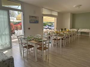 a dining room with a table and chairs and a room with at Hotel ai Fiori in Grado