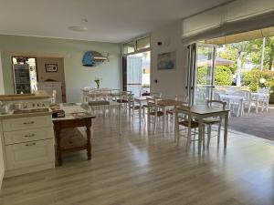 a kitchen and dining room with tables and chairs at Hotel ai Fiori in Grado