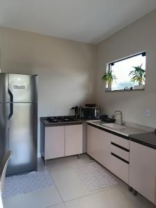 a kitchen with a stainless steel refrigerator and a window at Apartamento de dois quartos centro de Pomerode in Pomerode