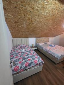 a bedroom with two beds and a wooden floor at Apartment Perović in Kotor