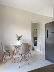 a dining room with a table and a refrigerator at Apartamento de dois quartos centro de Pomerode in Pomerode