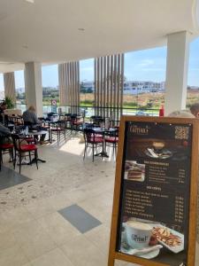a restaurant with tables and chairs and a sign at Loft a cinq minute de la plage in Temara