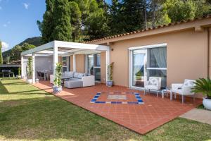 a patio with white furniture on a lawn at Villa Torre Conca Cefalu Coast in Finale
