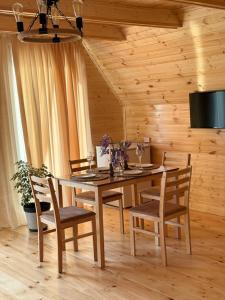 a wooden dining room with a table and chairs at Greenside Buknari in K'veda Ulianovka