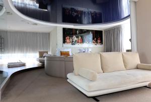 ein Wohnzimmer mit weißem Sofa und großem Fenster in der Unterkunft Oz'Inn Hôtel & Spa in Cap d'Agde