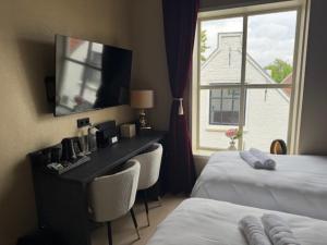 a hotel room with a desk and a window at Stadshotel Jacob Cats in Brouwershaven