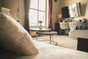 a bedroom with a bed and a table and a tv at Stadshotel Jacob Cats in Brouwershaven