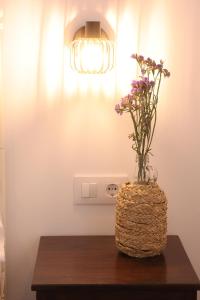 a vase of flowers on a table with a light at Casa Rural La Canaleja in Berrocalejo