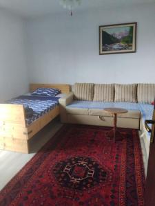 a room with two beds and a couch and a rug at Hiža Guesthouse in Sarajevo
