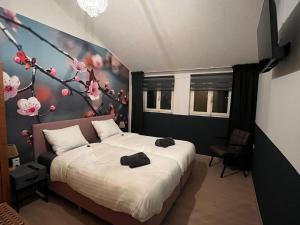 a bedroom with a bed with flowers on the wall at B&B Itterhoeve in Neeritter