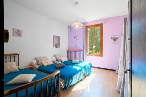 two beds in a room with purple walls at L'Envol - Oasis Ressource in Eyliac
