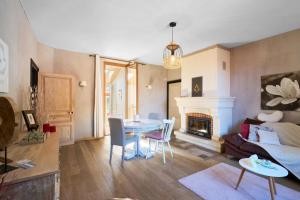 a living room with a table and a fireplace at L'Envol - Oasis Ressource in Eyliac +14 photos